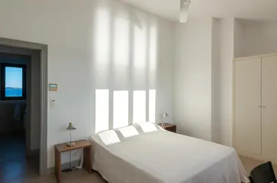 a bedroom with a white bed and a window at Les Salins in Porto-Vecchio