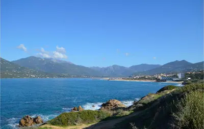 a view of a beach with mountains in the background at 1 Bedroom Lovely Apartment In Propriano in Propriano