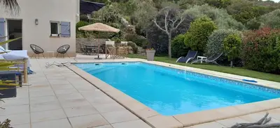 a swimming pool in a yard next to a house at studio 5min plage agosta in Albitreccia