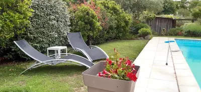 two chairs and a table next to a pool at studio 5min plage agosta in Albitreccia