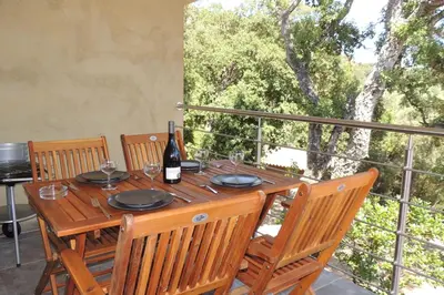 a wooden table with a bottle of wine on a balcony at L'Ortu Di Pisettu -2 in Conca