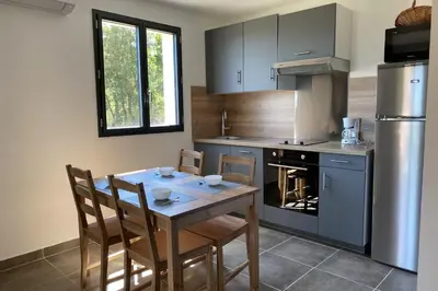 a kitchen with a table and chairs and a stove at L'Ortu Di Pisettu -2 in Conca