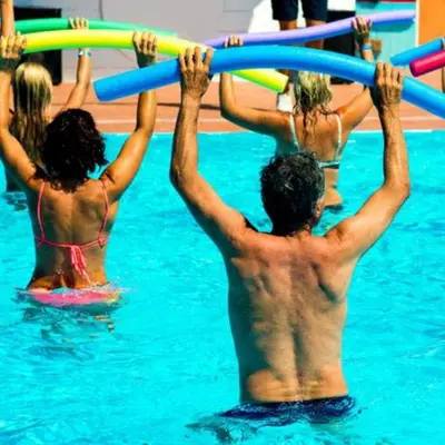 a group of people in the water holding up hoses at Vacances en Chalet ou Mobil-home chez Camp'in Pirellu in Porto-Vecchio