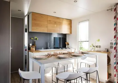 a kitchen with a white table and white chairs at Vacances en Chalet ou Mobil-home chez Camp'in Pirellu in Porto-Vecchio