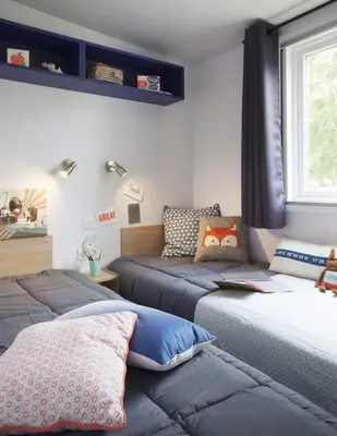 a bedroom with two beds and a window at Vacances en Chalet ou Mobil-home chez Camp'in Pirellu in Porto-Vecchio
