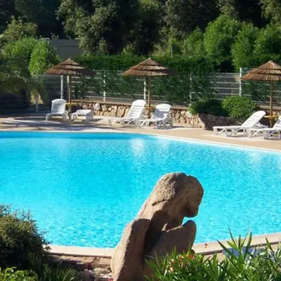 a large swimming pool with a statue in front of it at Vacances en Chalet ou Mobil-home chez Camp'in Pirellu in Porto-Vecchio
