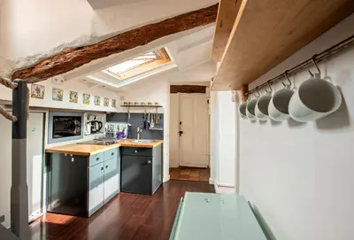 a kitchen with black appliances and a wooden floor at Toit Terrasse centre historique in Ajaccio