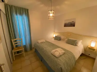 a bedroom with a bed with two towels on it at Santa Giulia - Le village de L'hacienda in Porto-Vecchio