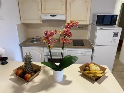 a kitchen with two baskets of fruit and a pineapple at Santa Giulia - Le village de L'hacienda in Porto-Vecchio