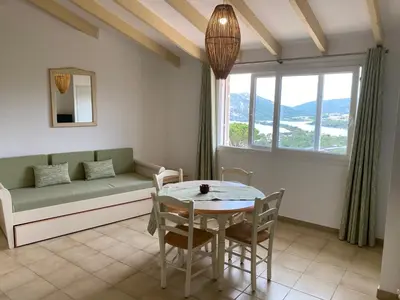 a living room with a table and a couch at Santa Giulia - Le village de L'hacienda in Porto-Vecchio