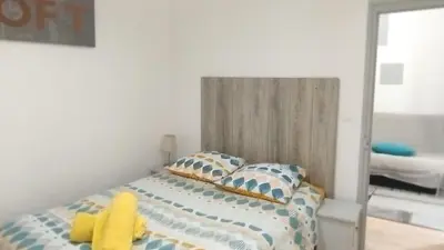 a bedroom with a bed with a yellow stuffed animal on it at T2 type new yorkais in Ajaccio
