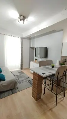 a living room with a table and chairs in a room at T2 type new yorkais in Ajaccio