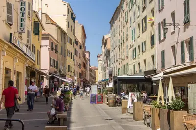 a street with people walking down a street with buildings at T2 type new yorkais in Ajaccio