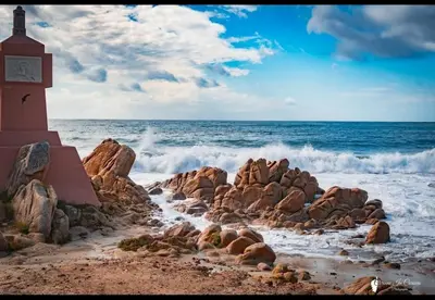 a clock tower on the beach next to the ocean at T2 type new yorkais in Ajaccio