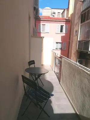 a table and two chairs sitting on a balcony at T2 type new yorkais in Ajaccio