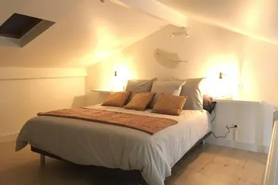 a bedroom with a large white bed with two pillows at Appartement neuf entre mer et montagne. in Furiani