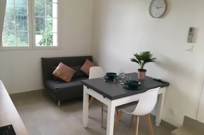 a living room with a table and a couch at Appartement neuf entre mer et montagne. in Furiani