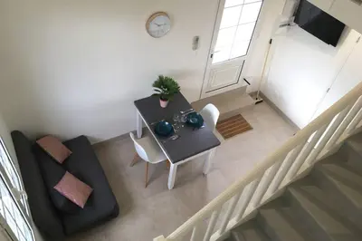 a living room with a table and a couch at Appartement neuf entre mer et montagne. in Furiani