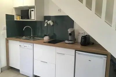 a kitchen with white cabinets and a sink at Appartement neuf entre mer et montagne. in Furiani
