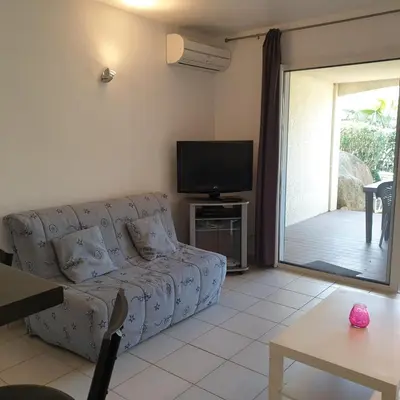 a living room with a couch and a tv at Appart RDC ALZETU CLIMATISE - 2 MIN PLAGE - PISCINE in Lecci