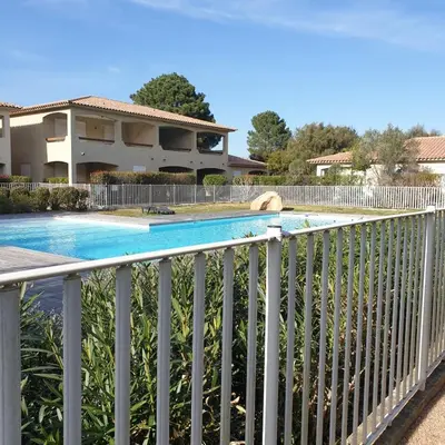 a fence around a swimming pool on a balcony at Appart RDC ALZETU CLIMATISE - 2 MIN PLAGE - PISCINE in Lecci