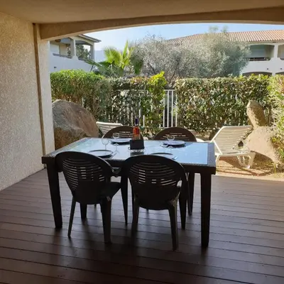 a table and chairs sitting on a deck at Appart RDC ALZETU CLIMATISE - 2 MIN PLAGE - PISCINE in Lecci