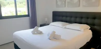 a bedroom with a large white bed with two pillows at Villa Tinuta 8 pers piscine chauffée 5 min plage en voiture in Sainte-Lucie de Porto-Vecchio