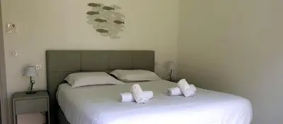 a bedroom with a bed with two white pillows at Villa Tinuta 8 pers piscine chauffée 5 min plage en voiture in Sainte-Lucie de Porto-Vecchio
