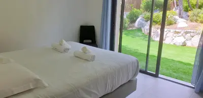 a bedroom with a bed with two white pillows on it at Villa Tinuta 8 pers piscine chauffée 5 min plage en voiture in Sainte-Lucie de Porto-Vecchio