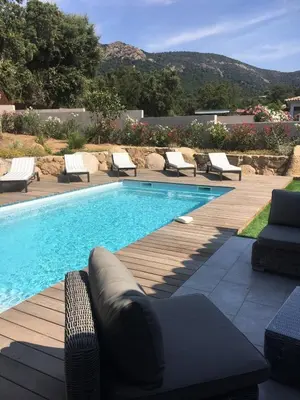 a swimming pool with chaise lounges and chairs around it at Villa Tinuta 8 pers piscine chauffée 5 min plage en voiture in Sainte-Lucie de Porto-Vecchio