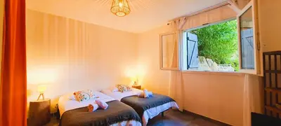 two twin beds in a room with a window at Appt Bruscaghju 6 pers 10 min rivière à pieds xx 15 min plage en voiture in Sainte-Lucie de Porto-Vecchio