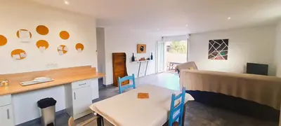 a kitchen with a table and a dining room at Appt Bruscaghju 6 pers 10 min rivière à pieds xx 15 min plage en voiture in Sainte-Lucie de Porto-Vecchio