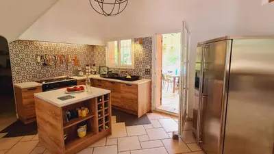 a kitchen with a stove and a refrigerator at Villa Lucendiluna 10 personnes piscine 5 min plage en voiture in Sainte-Lucie de Porto-Vecchio