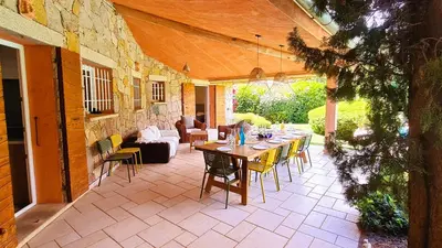 a patio with a table and chairs and a couch at Villa Lucendiluna 10 personnes piscine 5 min plage en voiture in Sainte-Lucie de Porto-Vecchio