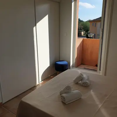 a bed with towels on it with a large window at Mini villa Messicana 5 pers piscine 500 m plage in Lecci