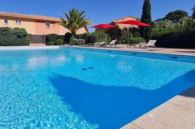 a swimming pool with blue water in front of a house at Mini villa Messicana 5 pers piscine 500 m plage in Lecci