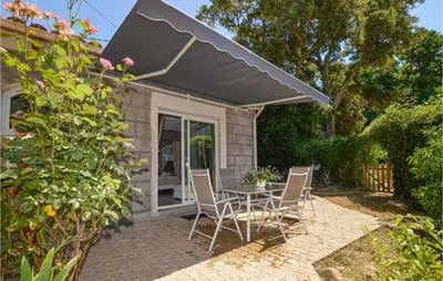 a patio with a table and chairs under an umbrella at Awesome Home In Petreto Bicchisano in Petreto-Bicchisano