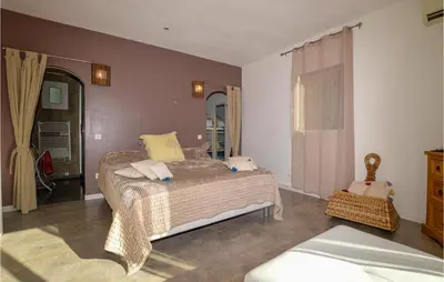 a bedroom with a bed and a dresser at Awesome Home In Petreto Bicchisano in Petreto-Bicchisano
