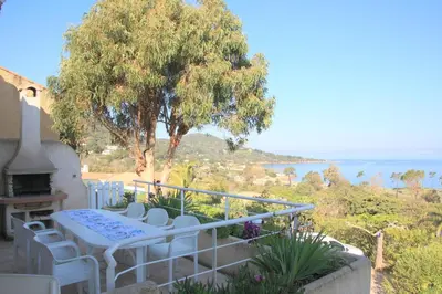 a balcony with a table and chairs and a tree at La villa Acacia in Coti-Chiavari