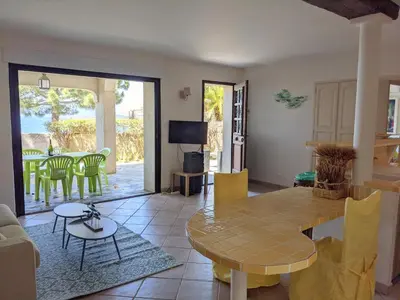 a living room with a table and a dining room at La villa Acacia in Coti-Chiavari