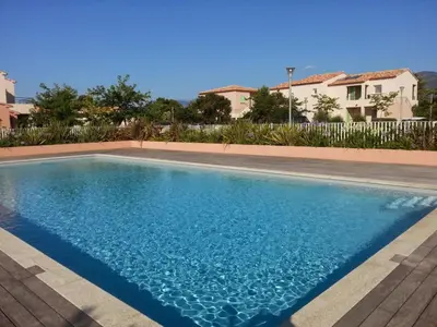a swimming pool with blue water in front of a house at Lecci St Cyprien Don Andria in Porto-Vecchio
