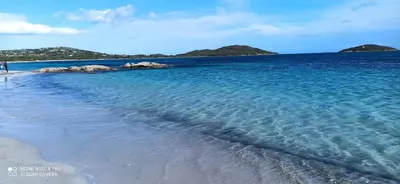 a beach with blue water and islands in the background at Lecci St Cyprien Don Andria in Porto-Vecchio
