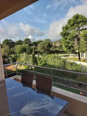 a table and two chairs on a balcony with a view at Lecci St Cyprien Don Andria in Porto-Vecchio