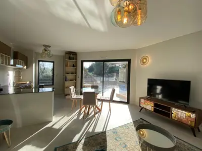 a kitchen and living room with a table and chairs at Porto-Vecchio, Luxe et lumière, Stanatura in Porto-Vecchio