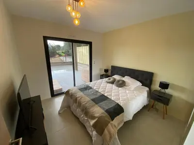 a bedroom with a bed and a large window at Porto-Vecchio, Luxe et lumière, Stanatura in Porto-Vecchio