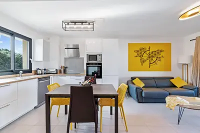 a kitchen and living room with a table and a couch at Porticcio - T2 neuf à 5min à pieds de la plage in Porticcio