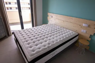 a bed in a room with a large window at Porticcio - T2 neuf à 5min à pieds de la plage in Porticcio