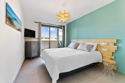 a bedroom with a large bed and a television at Porticcio - T2 neuf à 5min à pieds de la plage in Porticcio