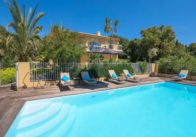 a swimming pool with chairs and a house at Villa RUSCANA AVEC PISCINE PRIVÉE in Sainte-Lucie de Porto-Vecchio