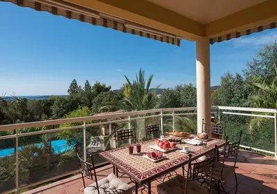 a table and chairs on a balcony with a view at Villa RUSCANA AVEC PISCINE PRIVÉE in Sainte-Lucie de Porto-Vecchio
